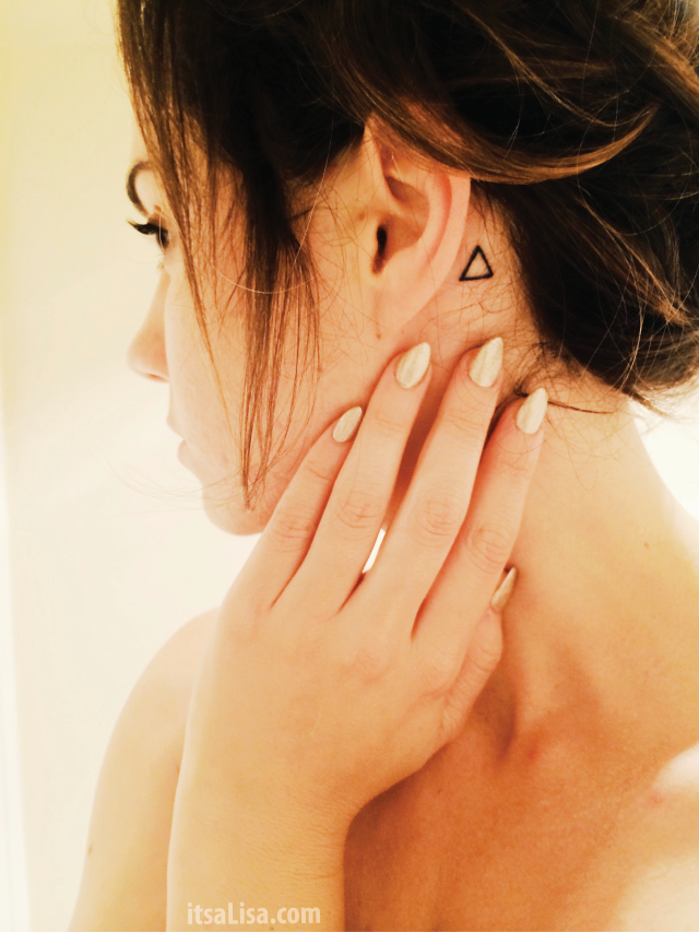 claw nails and simple behind the ear triangle tattoo